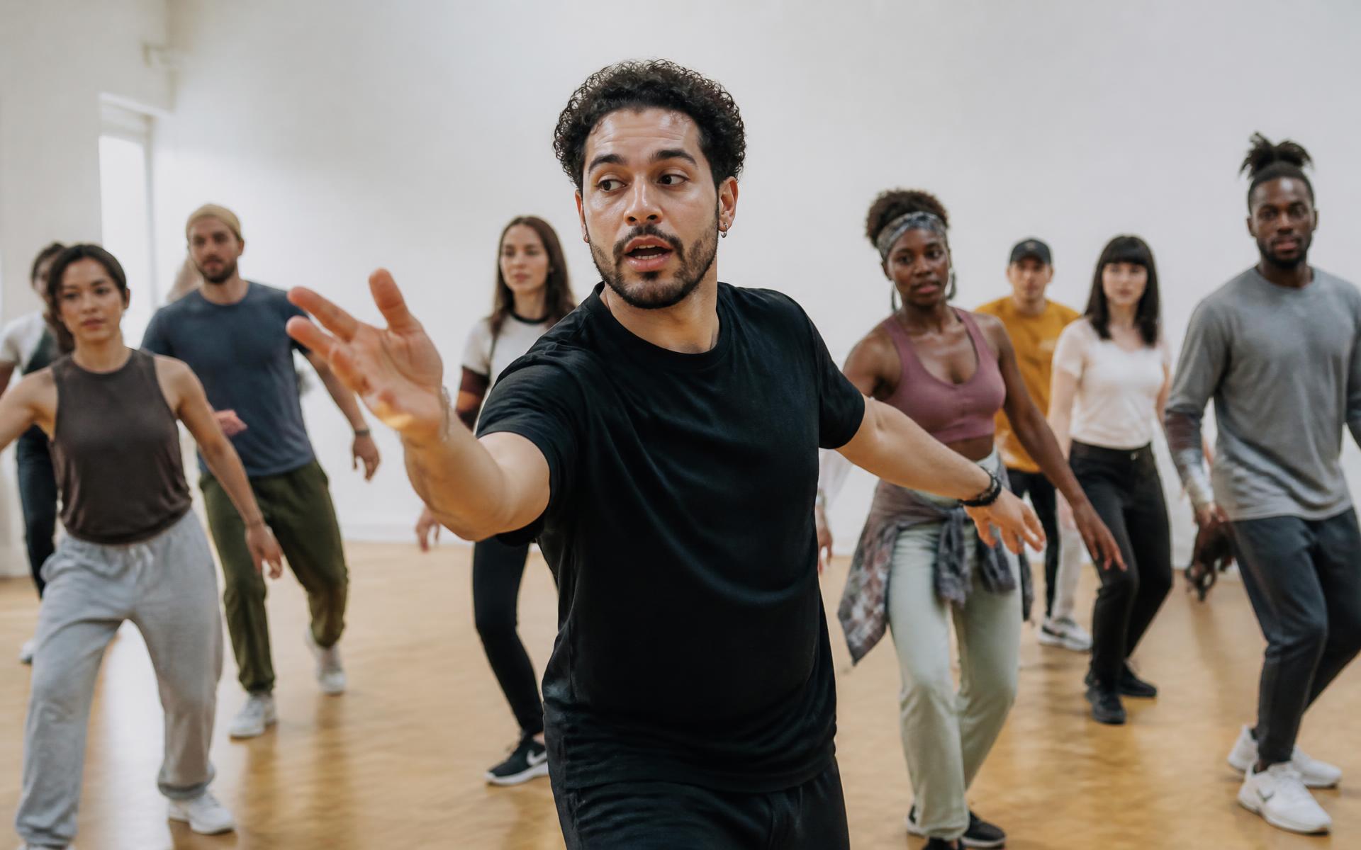 A dance instructor demonstrating a move to a class